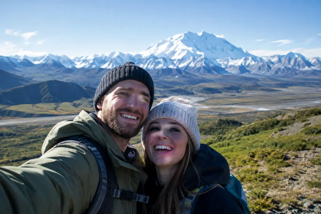 Denali road access checkpoint with snowy park road and forested mountains